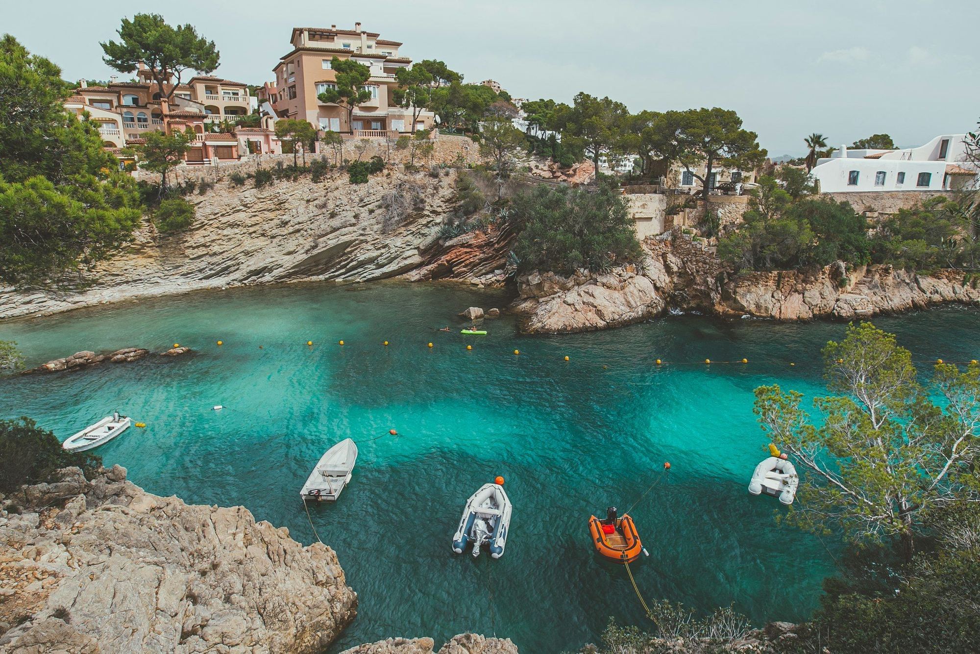 Cala de aguas turquesa con barcos fondeados